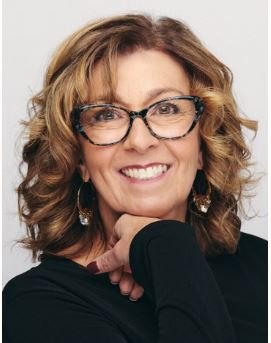 Karen Curry Parker, une femme qui sourit avec lunettes.